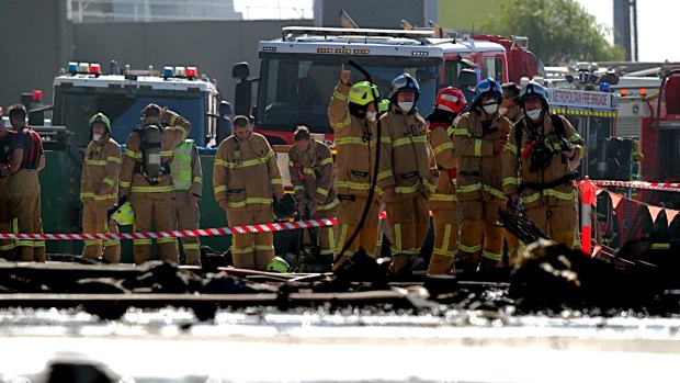 Firefighters at the scene of the plane crash at the Essendon DFO. 