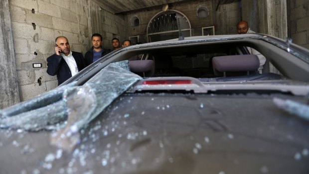Fayez Abu Eitta, a Fatah leader in Gaza,  inspects the damage to his car.