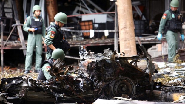 Thai bomb squad officers examine the wreckage of a car after an explosion outside a hotel in Pattani province, southern Thailand, on Wednesday.
