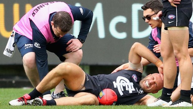 The agony: Chris Judd goes to ground after injuring his knee.