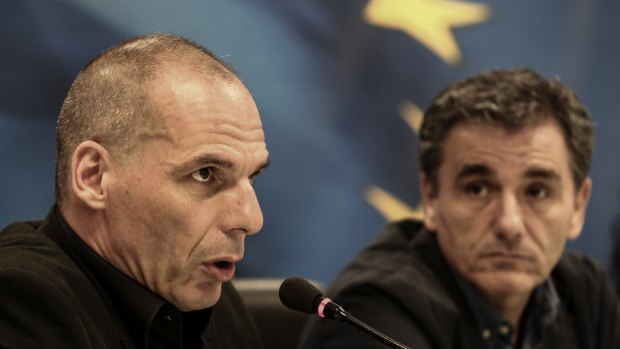 Euclid Tsakalotos (right) looks on as outgoing finance minister Yanis Varoufakis hands over the reins.