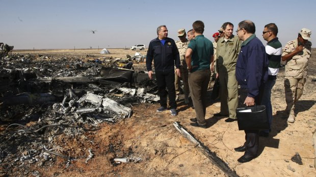 Russian Emergency Situations Minister Vladimir Puchkov, left, talks with Russian Transport Minister Maxim Sokolov, fifth right, as they inspect the wreckage of a passenger jet bound for St. Petersburg that crashed in Egypt.