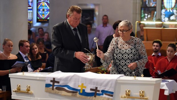 Steven and Mary-Leigh Miller sprinkle holy water on the coffin of their son, 18 year-old one-punch victim Cole Miller.