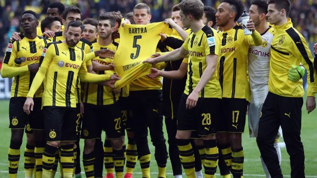Tribute: Dortmund players hold the jersey of injured teammate Marc Bartra at the weekend.