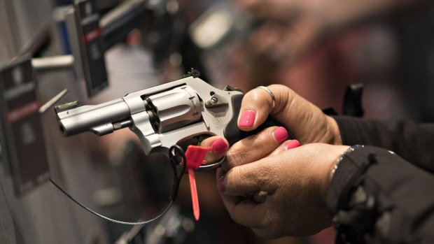 A woman handles a gun at the National Rifle Association annual show in Nashville in 2015.