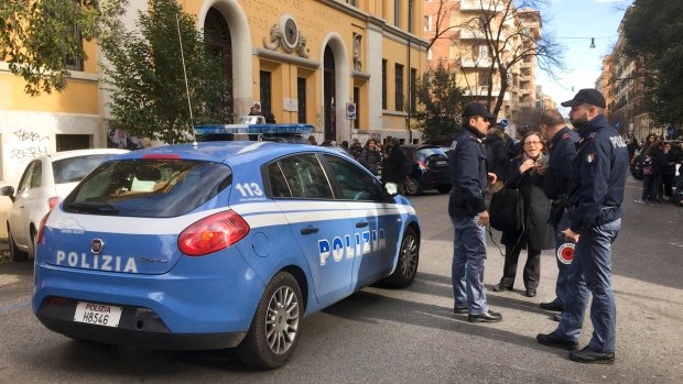 Italian police stand by an evacuated school.