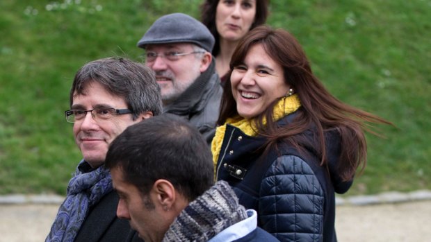 Ousted Catalan leader Carles Puigdemont, left, walks in the park with elected Catalan lawmakers of his Together for Catalonia party in Brussels on Friday.