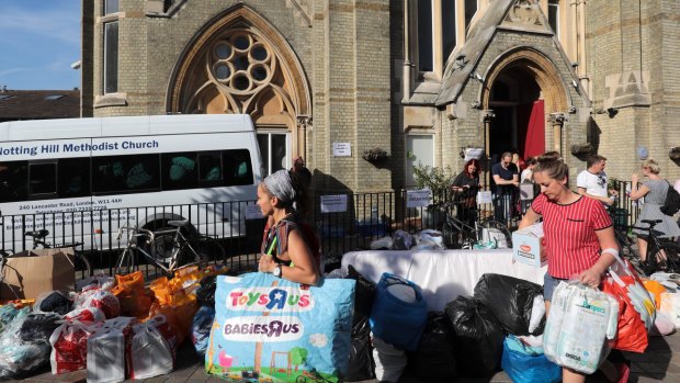 People leave donations outside the Notting Hill Methodist Church near the burning 24-storey residential Grenfell Tower block.