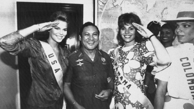 July 1986:  Miss USA, Christy Fichtner, left, and Miss Panama, Gilda Garcia Lopez, salute while flanking Manuel  Noriega in Panama City. 