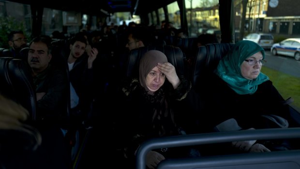 Iraqi refugee Fatima Hussein, 65, (centre) and others wait in a bus heading to a government interview for their asylum seeking process in Haarlem, Netherlands.