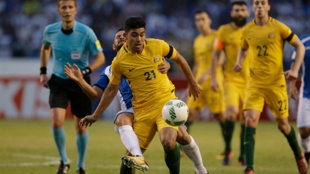 Australia's Massimo Luongo (21) controls the ball ahead of Honduras' Alfredo Mejia at the Olympic Stadium in San Pedro Sula.