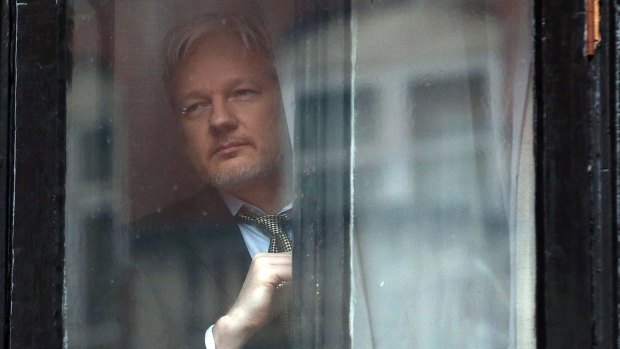 Julian Assange looks out from the Ecuadorian embassy in London,  where he took refuge in June 2012 to avoid extradition to Sweden.