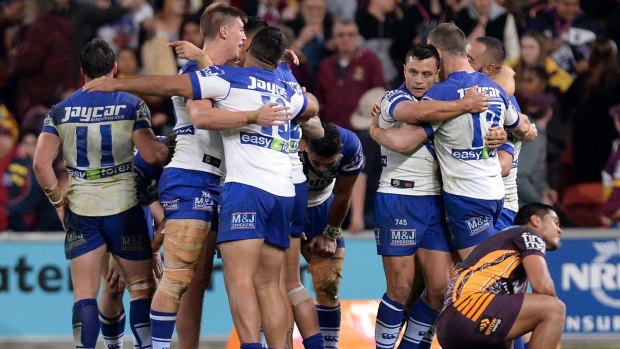 Bulldogs players celebrate beating the Broncos in Brisbane.