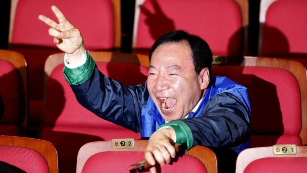 A member of the Minjoo Party reacts as he watches the results of exit polls for the parliamentary elections in Seoul, on Wednesday.