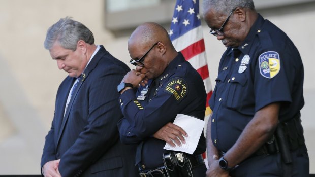 Dallas police chief David Brown, centre, in a candle light vigil at Dallas City Hall on Monday.