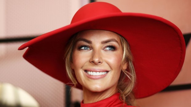 Jennifer Hawkins in a red jumpsuit by Misha Collection. And hat.