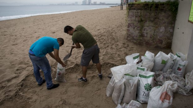 Men fill bags with sand from the beach as they prepare for the arrival of Hurricane Patricia in Puerto Vallarta.