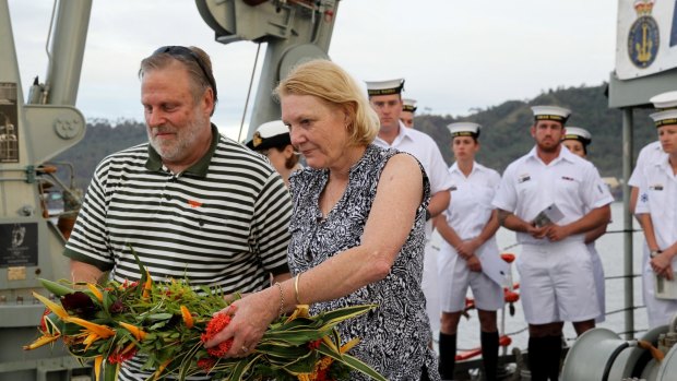 A time to remember: Graham and Robyn Rosentrauss prepare to drop flowers off the stern of HMAS Yarra.