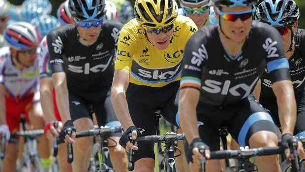 Sitting pretty: Sky's Christopher Froome, wearing the overall leader's yellow jersey, rides in the pack during Saturday's eighth stage.