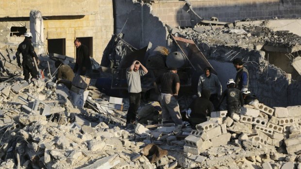 Civilians caught in the war: People look for survivors amid debris after barrel bombs were reportedly dropped by forces loyal to Bashar al-Assad in Aleppo.