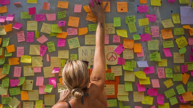 A woman leaves a message on a memorial board on Barcelona's historic Las Ramblas promenade on Friday.