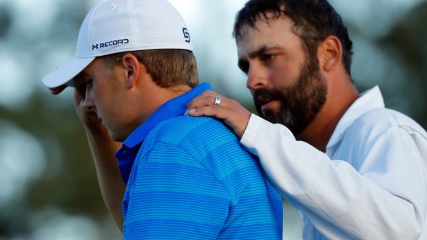 Jordan Spieth is comforted by caddie Michael Greller after imploding on the last nine holes of the Masters on Sunday. 