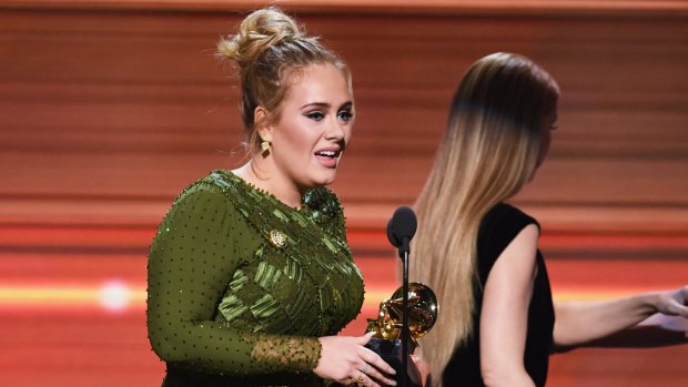Adele collects the Grammy for Song of the Year for <i>Hello</i>.