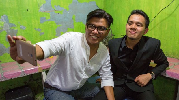 Filmmaker Noor Huda Ismail (left) and student Teuku Akbar Maulana take a selfie using a smartphone in Jakarta.