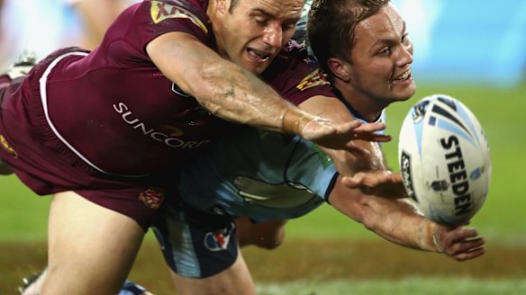 Cameron Smith of the Maroons and Matt Moylan of the Blues fight for the ball.