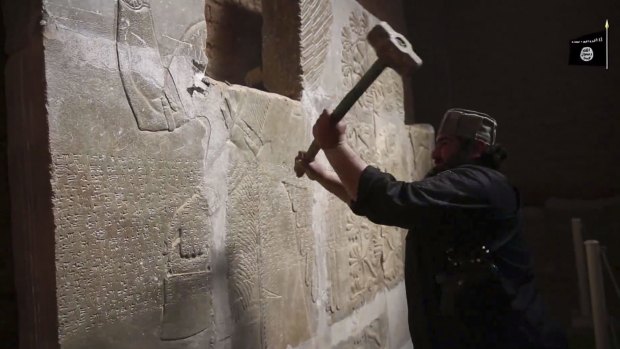 An Islamic State jihadist takes a sledgehammer to carvings in the ancient Iraqi Assyrian city of Nimrud.