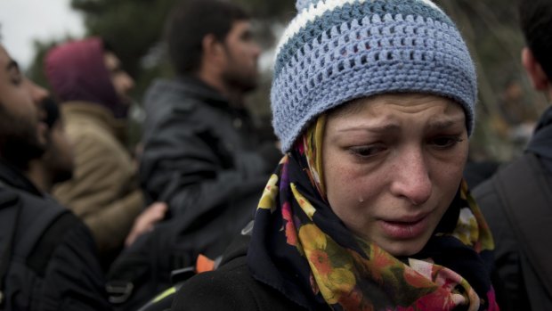 A woman cries as refugees and migrants protest in front of the border gate that separates Greece with Macedonia near the northern Greek village of Idomeni.