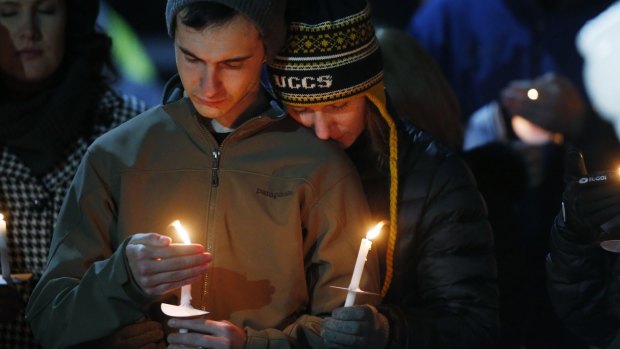 R.J. Canales, left, and his wife, Lauren, who are alumni of the University of Colorado, take part in a candlelight vigil held on University of Colorado-Colorado Springs' campus for those killed deadly shooting at a Planned Parenthood clinic