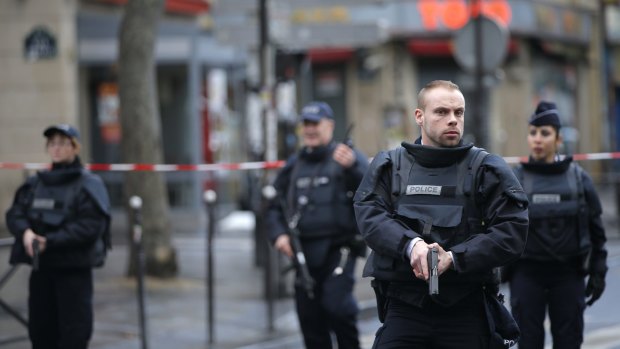 Police officers secure the perimeter near the scene of a fatal shooting and suspected terrorist attack that took place at a police station in Paris, Wednesday.