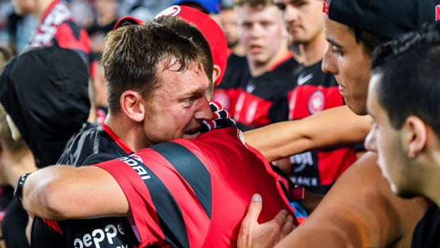 Distress: Brendon Santalab is consoled by Wanderers fans after the 5-0 defeat.