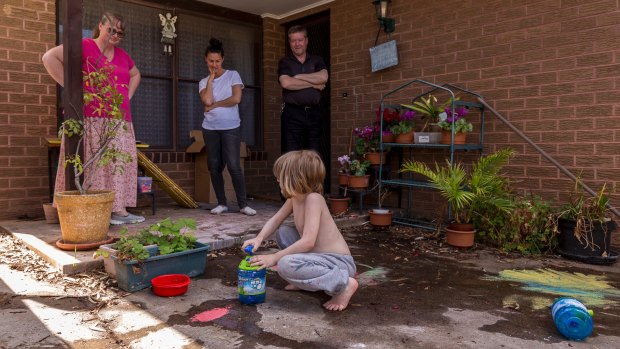 Alex playing outside is watched by mum, Martina, far left, his support worker, and his dad, Rodney.