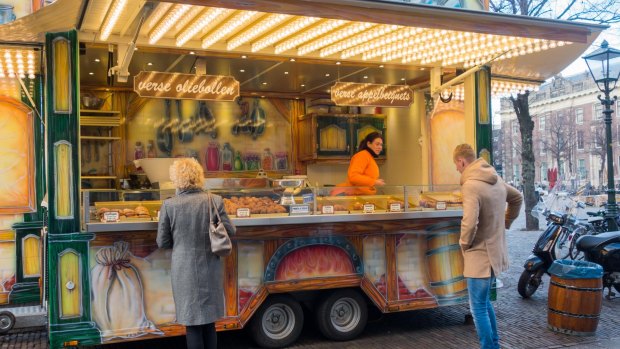 People buying fresh oliebollen at a street vendor in The Hague, Netherlands.