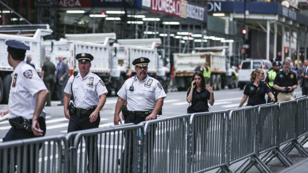 New York Police Department (NYPD) officers walk past barricades during a rally outside Trump Tower.