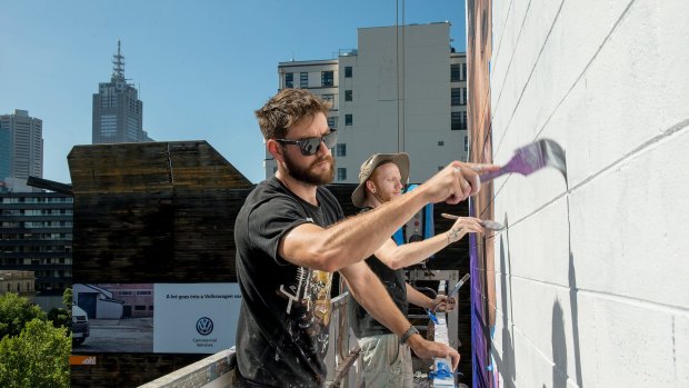 Artists Jason Parker and James Dewing  work on the Zoolander 2 mural.