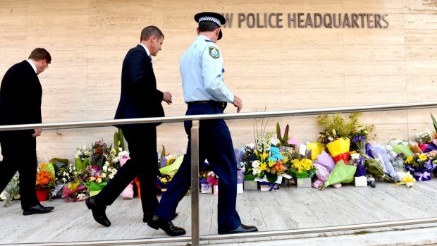 Premier Mike Baird walks past the many floral tributes left for  NSW Police accountant Curtis Cheng outside Parramatta Police headquarters.
