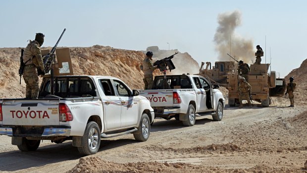 Smoke rises while Iraqi security forces and local tribal fighters attack Rawah.