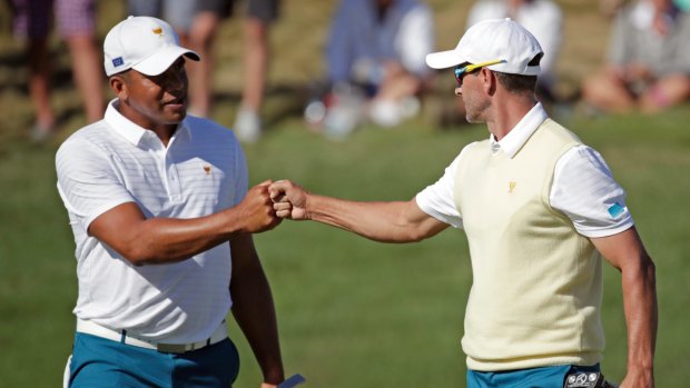 Fist bump: Adam Scott, right, and Jhonttan Vegas, left, celebrate early on the second day of the Presidents Cup.