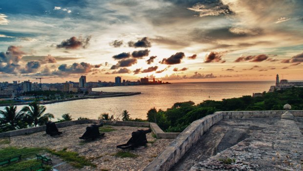 The Havana skyline and bay entrance taken from el Morro Fortress at dusk.