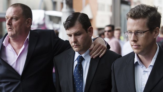 James Ian Longworth (centre), charged with hitting bouncer Fady Taiba, leaves Downing Centre District Court during his trial.