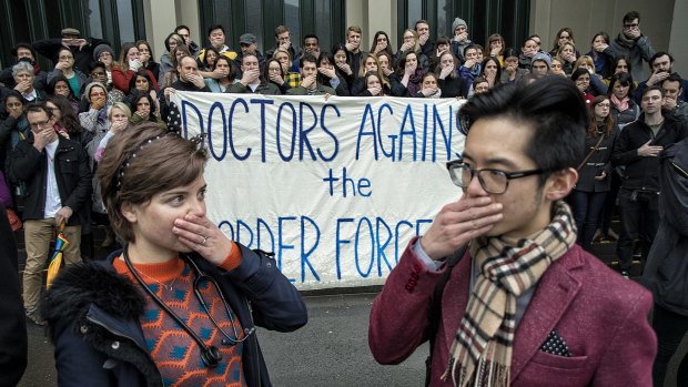 A group called Doctors Against the Border Force Act hold a silent protest at Carlton Gardens on Saturday.