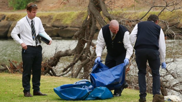 Police investigating the death of Brendan Bernard take away evidence from the banks of the Maribyrnong River. 