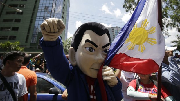 A mascot of presidential candidate Rodrigo Duterte kisses the Philippine flag in Pasig, east of Manila.