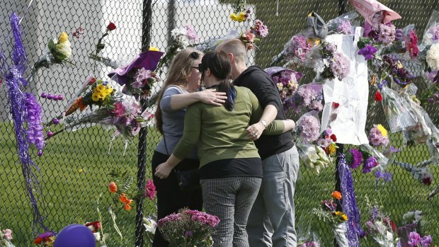 Prince fans embrace by a makeshift memorial outside Paisley Park, the home of singer Prince.