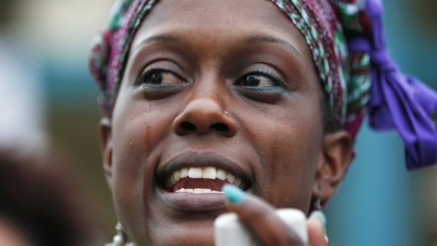 Omega Menders cries as she leads a rally over the police shooting of  Anthony Hill in Decatur, Georgia.