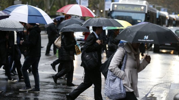 Commuters brave the rain in Sydney on Monday.