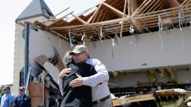US Energy Secretary Rick Perry, right, receives a hug during a stop at the First Baptist Church in Rockport, Texas, as he tours areas affected by Harvey. 
